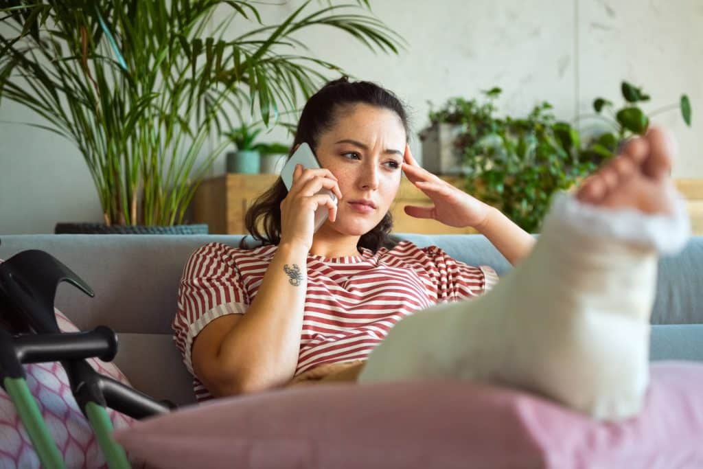 An injured woman on the phone with her lawyer after being injured in an accident