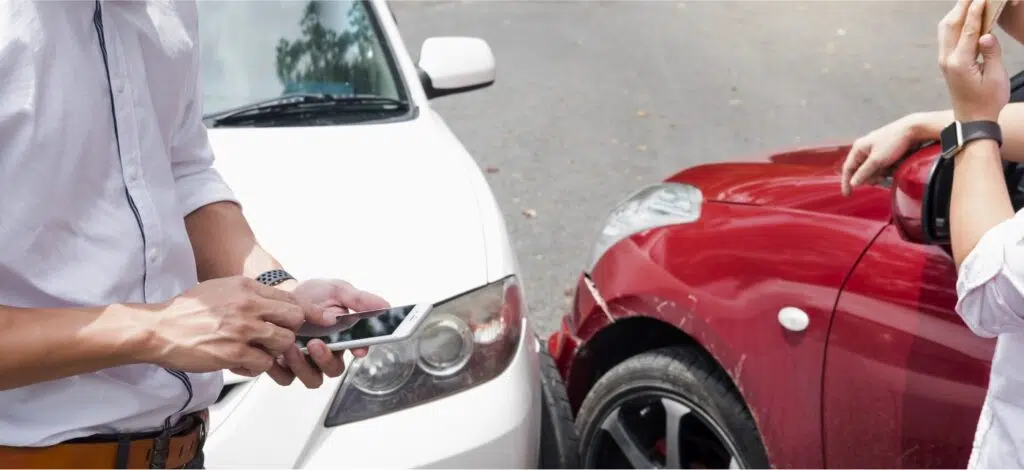 Two people exchanging contact info after an auto accident