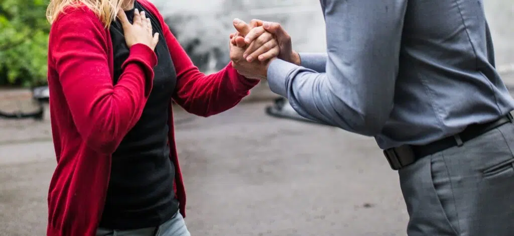 A person talking with witnesses after a car crash
