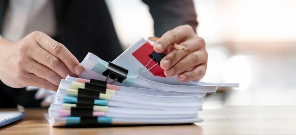 A person sorting paperwork pertaining to a car accident