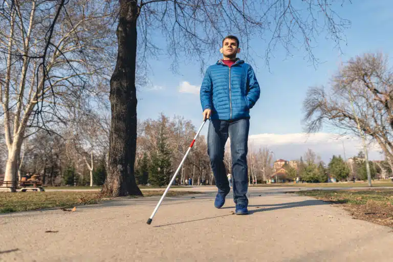 A blind man out on a walk.