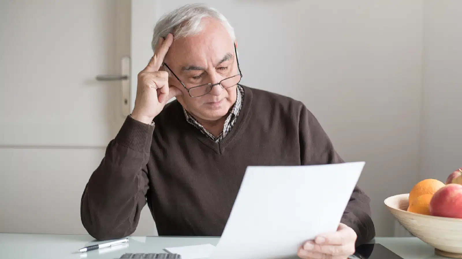 Elderly Man Reviewing His Finances Alone Stock Photo