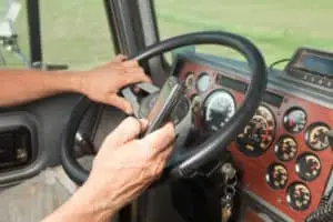 A truck driver distracted by his phone while driving.