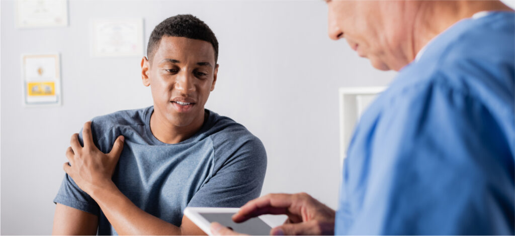 A man discussing a shoulder injury with a medical professional after an accident