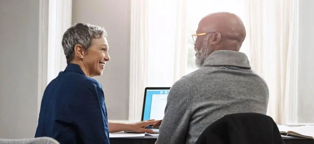 Two people talking in front of a computer