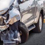 A car with front corner damage after an accident with a truck
