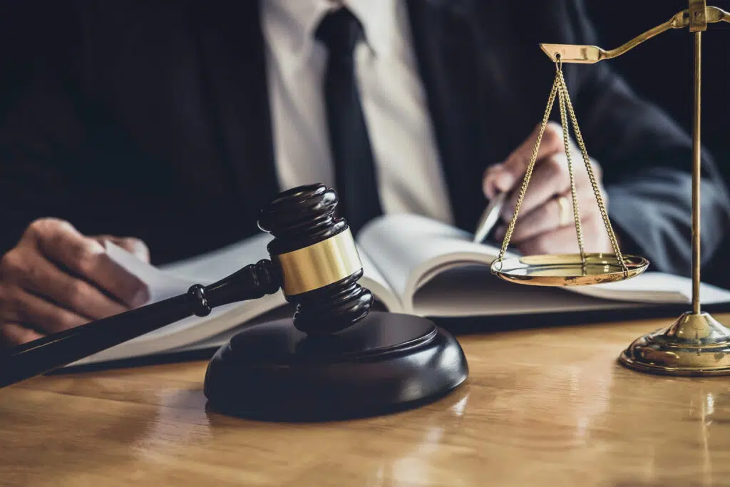 Male lawyer or judge working with contract papers, Law books and wooden gavel on table in courtroom, Justice lawyers at law firm,