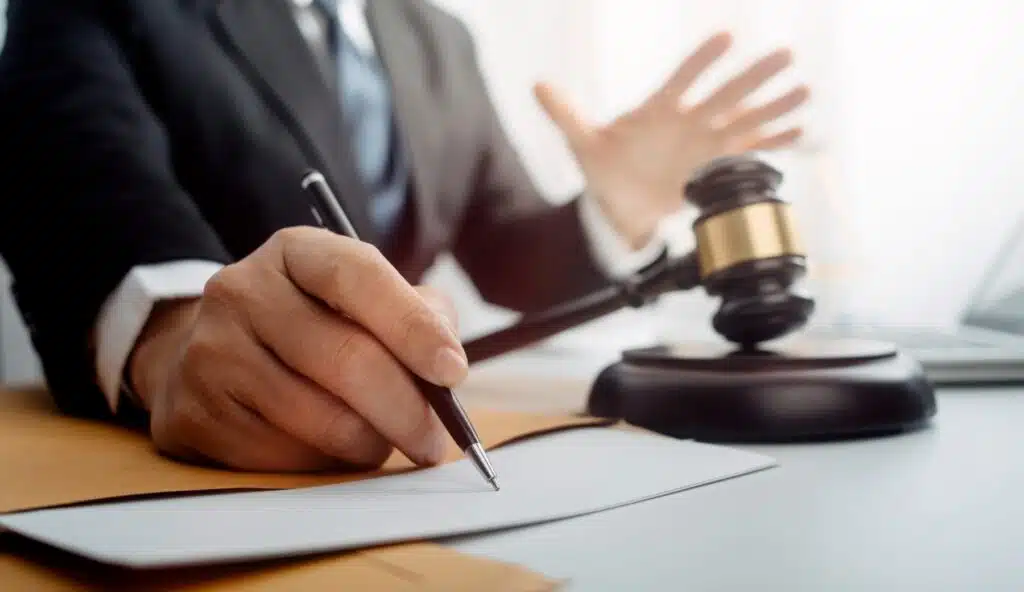Closeup of a social security lawyer with a pen and a gavel and paperwork