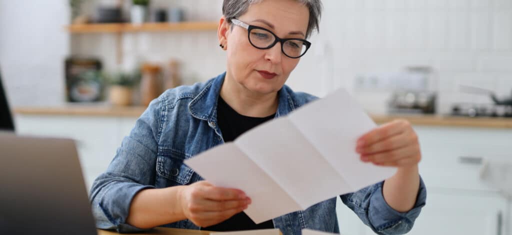 A women reviews a settlement offer on a printed piece of paper.