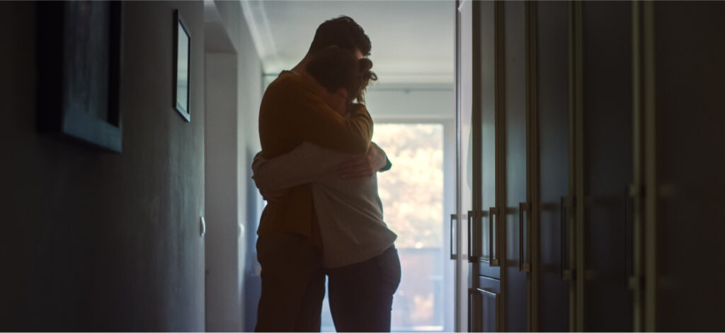 Two family members, a young man and a young woman, embrace in grief after the wrongful death of a loved one.