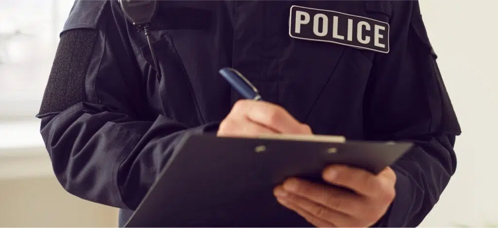 A police officer writes down information after a crash