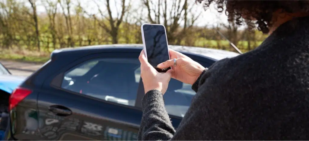 A woman uses her photo to take photos of an accident scene after a car crash.