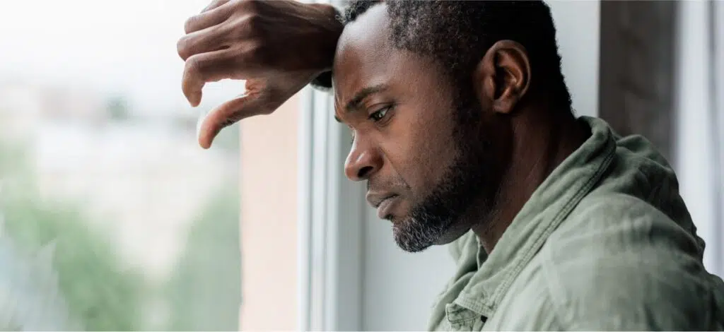 A man sadly looks out the window after a car crash