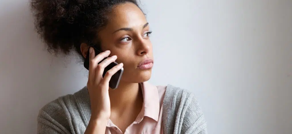 A woman talks on the phone with the insurance company after an auto accident