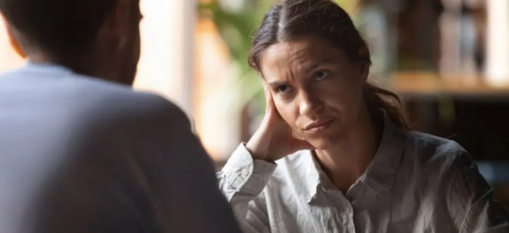 A woman sits with a personal injury attorney, considering whether to withhold information.