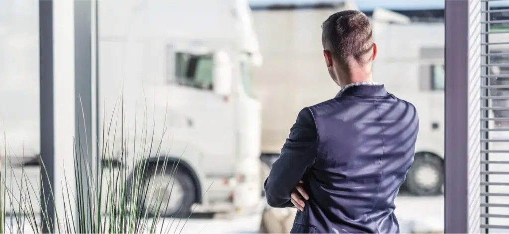 A man stands and looks at a semi truck.