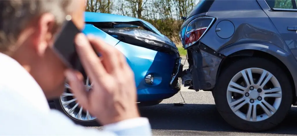 A person talking on the phone right after a car accident
