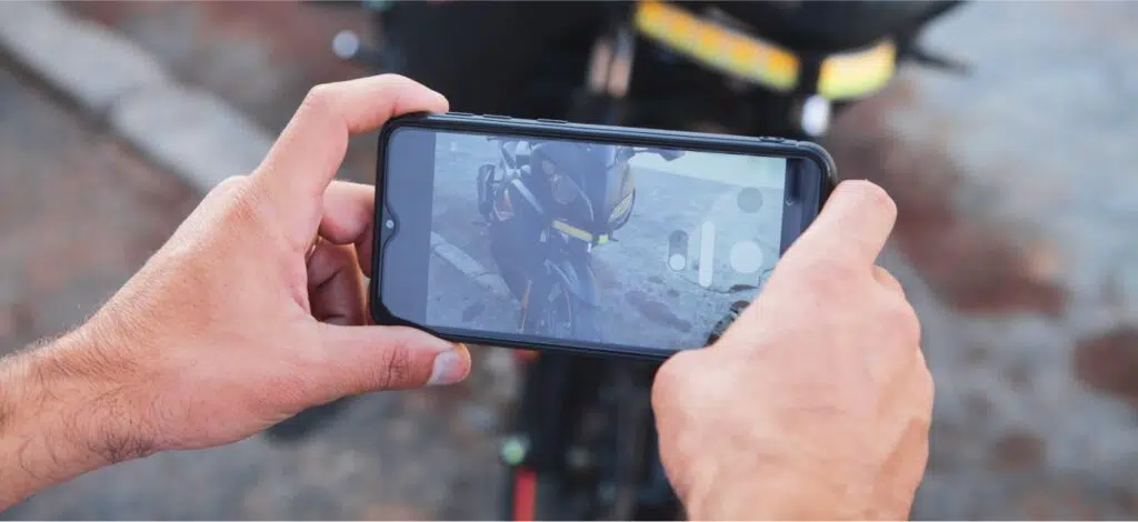 a person taking photos of damage from a motorcycle accident