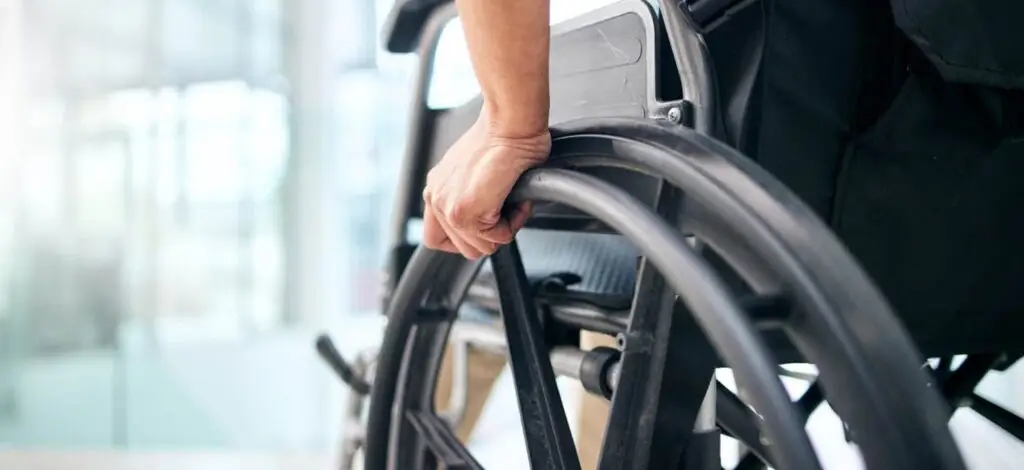 closeup of a person's hand wheeling a wheelchair 
