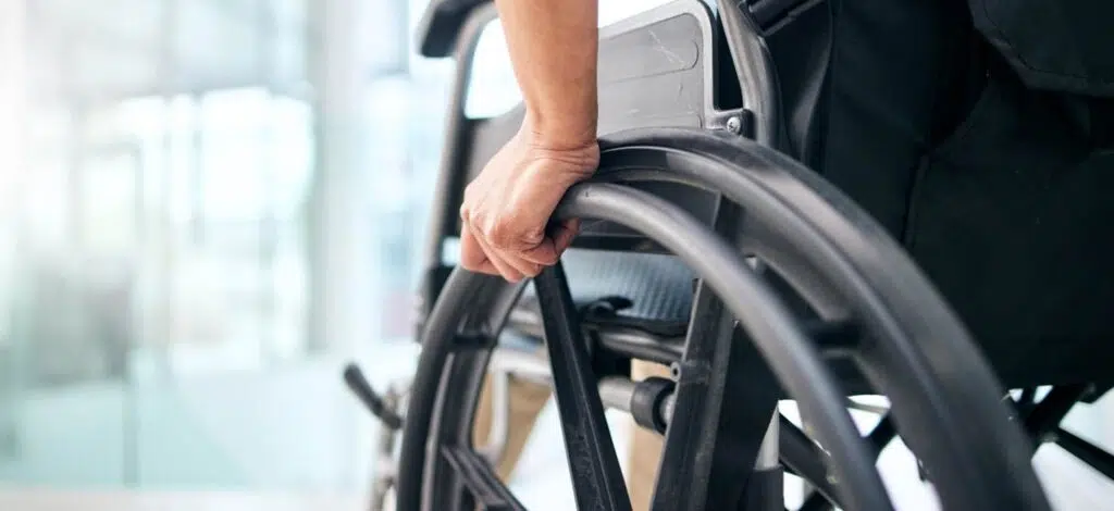 closeup of a person's hand wheeling a wheelchair