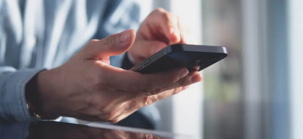 closeup of a person typing on a cell phone after a car accident