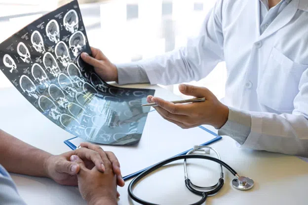 Doctor reviewing brain MRI scans with patient during consultation