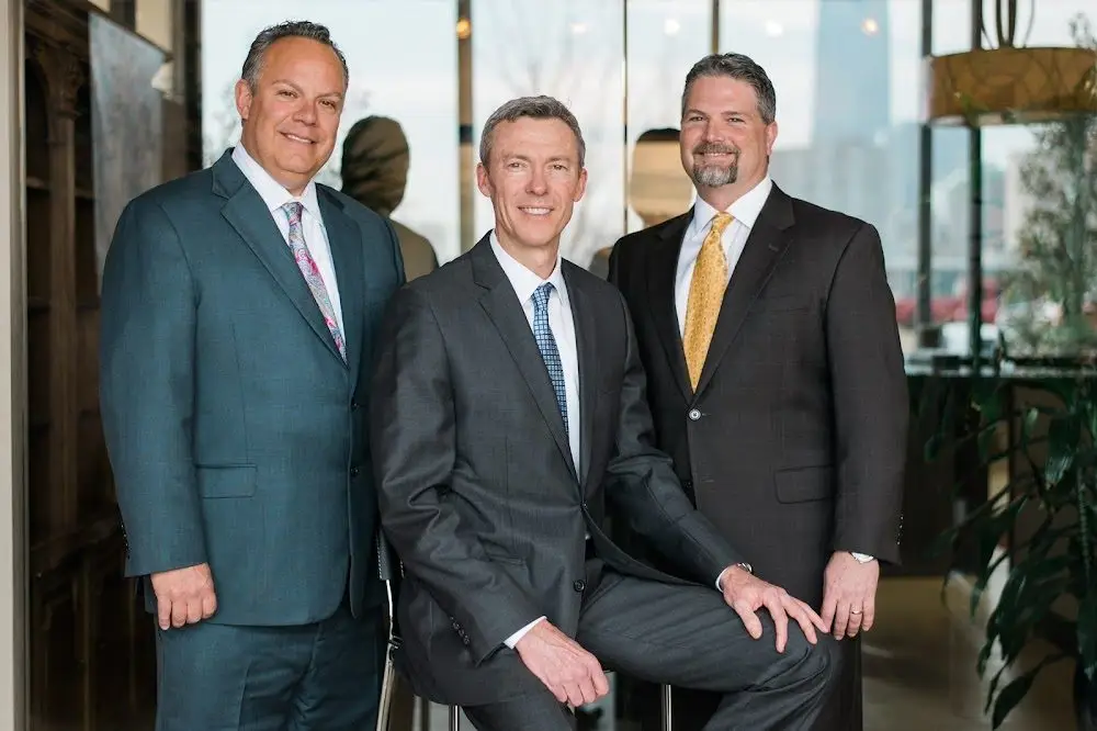 Three Colbert Cooper Hill attorneys standing in business suits